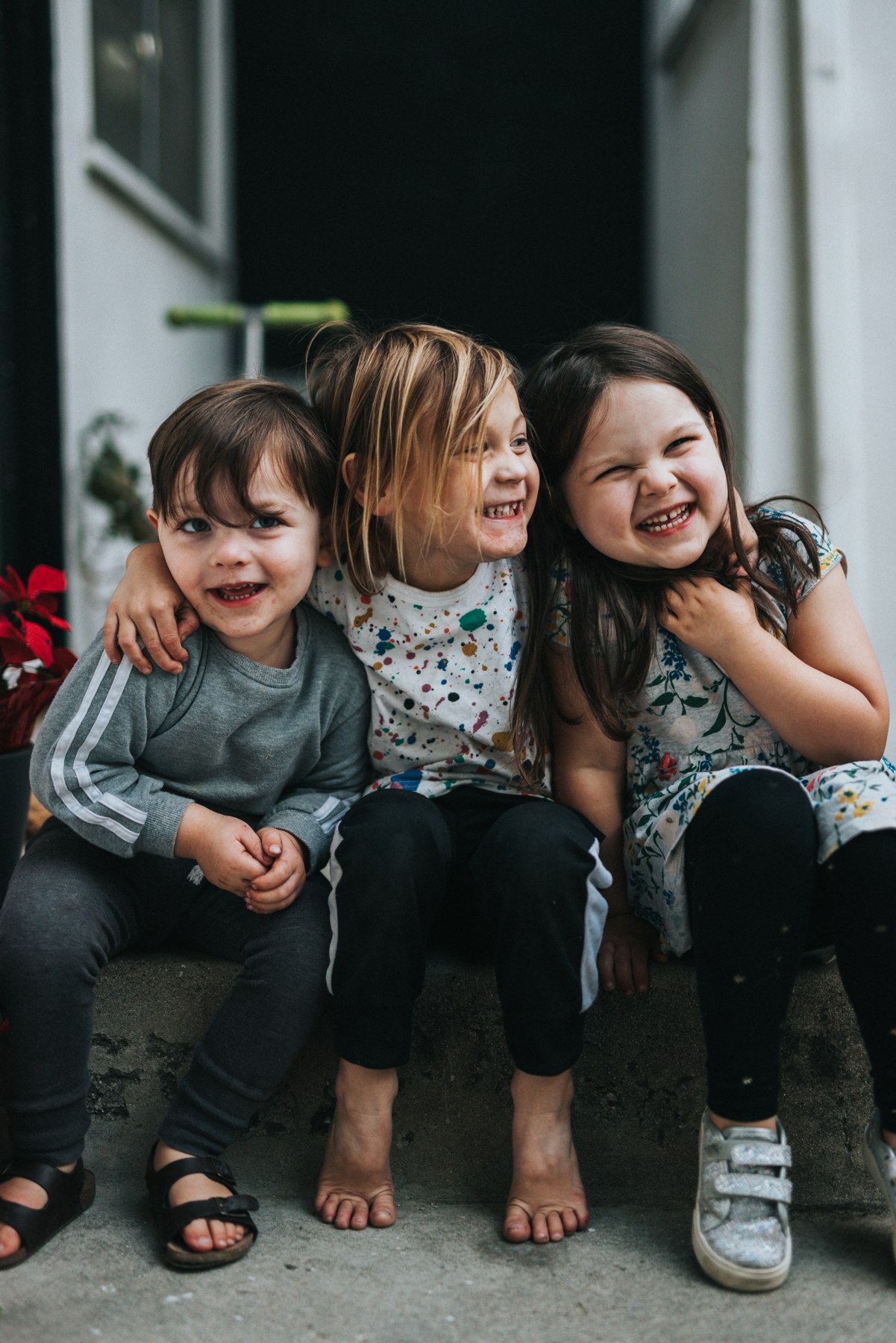 Three children sitting together outdoors